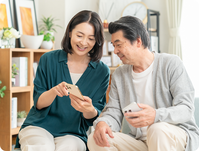 スマートフォンを見ながら話し合う夫婦